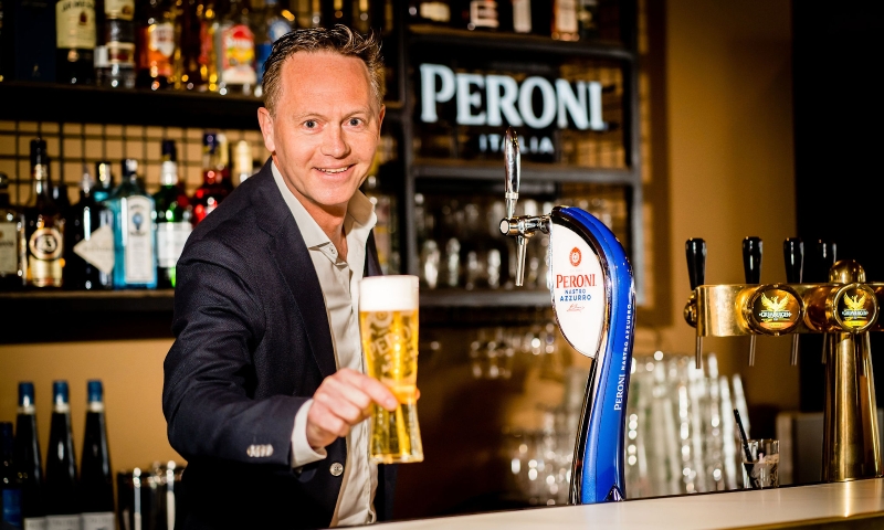 Floris van den Berg achter de bar met getapte Peroni Nastro Azzurro in de hand